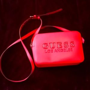 Small hot pink (Guess) shoulder crossbody bag with long adjustable strap.